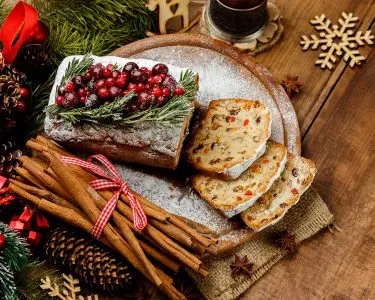 Homemade christmas cake with wild berries on woonen background