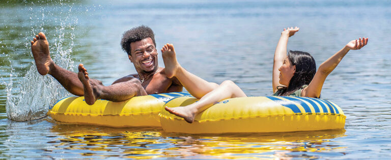 guy and girl tubing on a river