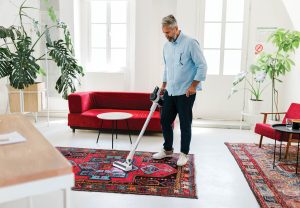 Man cleaning house with wireless vacuum cleaner