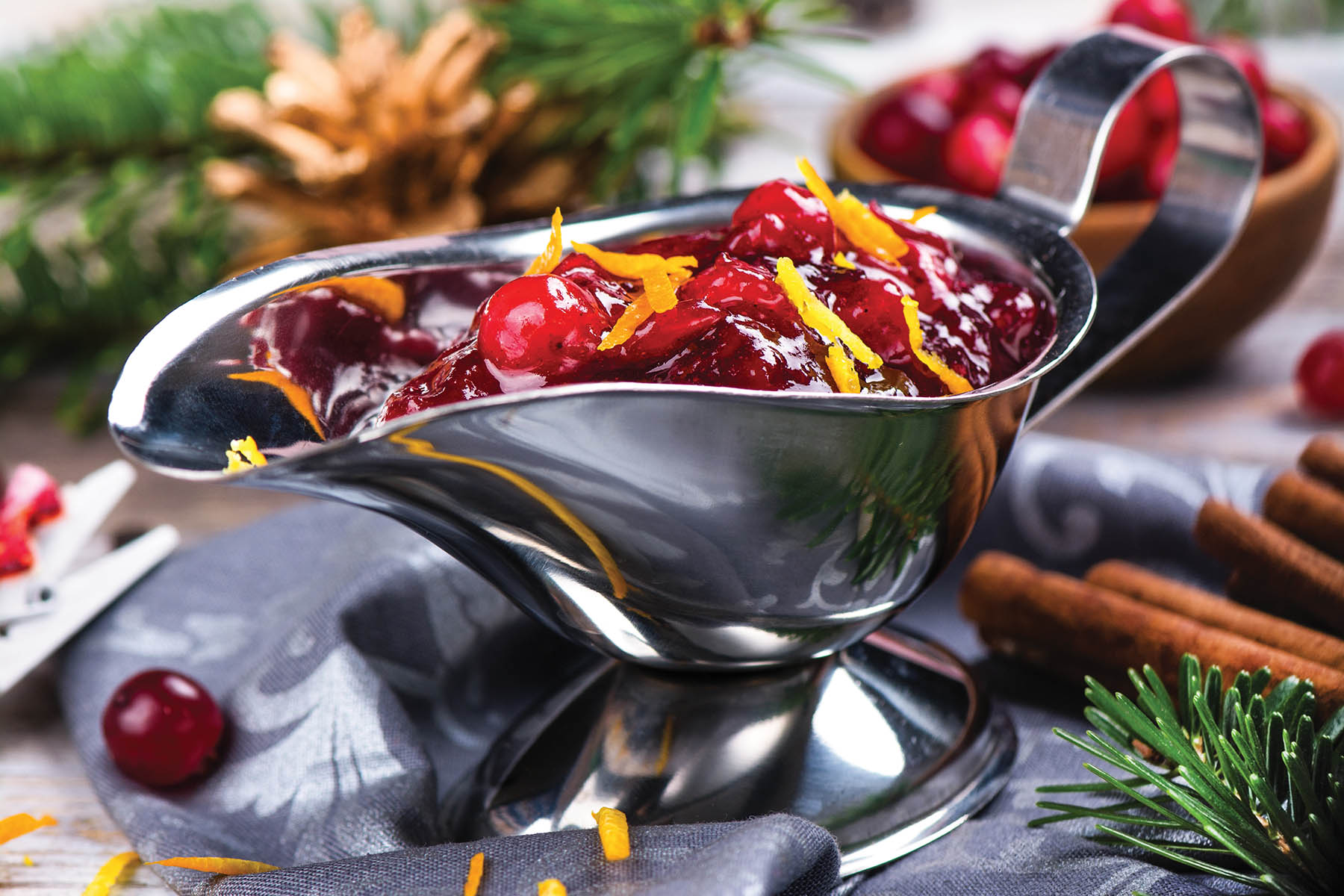 Cranberry sauce in a stainless steel sauce pan on festive christmas background