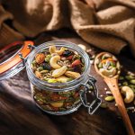Mix of healthy nuts and seeds in a container shot on rustic wooden table
