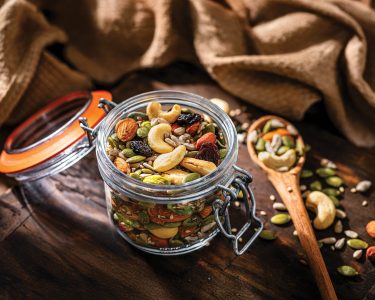 Mix of healthy nuts and seeds in a container shot on rustic wooden table