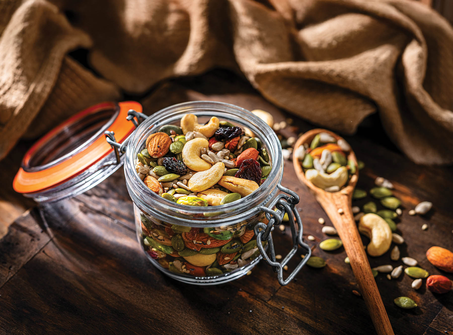 Mix of healthy nuts and seeds in a container shot on rustic wooden table