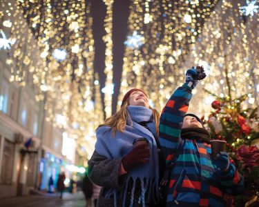 Little boy with his mother buying tera and sweets at a Christmas market