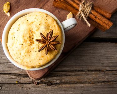 Pumpkin mug-cakes in rustic style, on an old wooden table, next to pumpkins