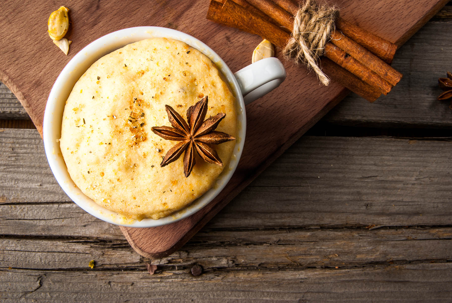 Pumpkin mug-cakes in rustic style, on an old wooden table, next to pumpkins