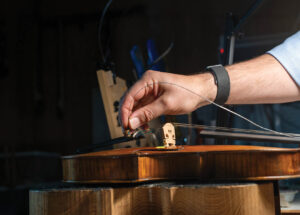 man fixing a violin